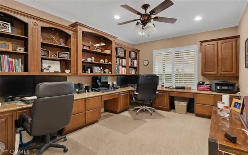 Gorgeous home office with extensive built-ins and plantation shutters