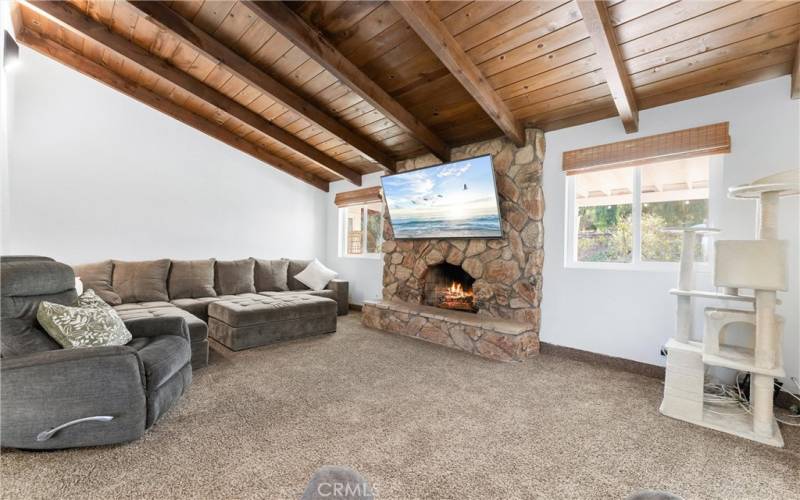 Spacious living room area with high beam ceilings. Enjoy your rock fireplace with a roaring fire for those cooler nights.