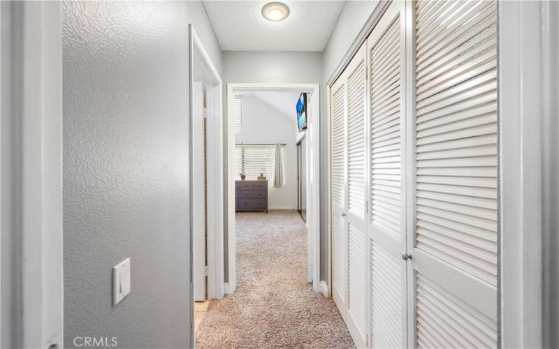 Hallway toward bathroom and bedroom closet doors 1 storage 2 laundry