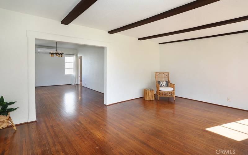 Living room and dining room space with original oak floors.