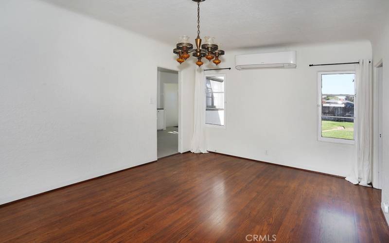 A vintage chandelier accents the large dining room. A mini split, professionally installed in 2021, is flanked by two windows over looking the back yard and allowing a very nice cross breeze.