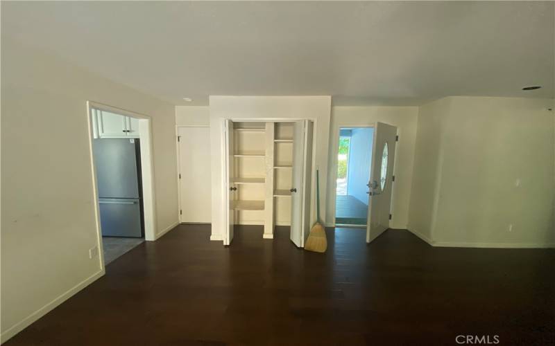 Living area looking toward front door with hall closet and door to garage