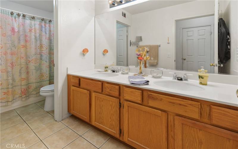 Secondly bathroom with dual sinks and bathtub