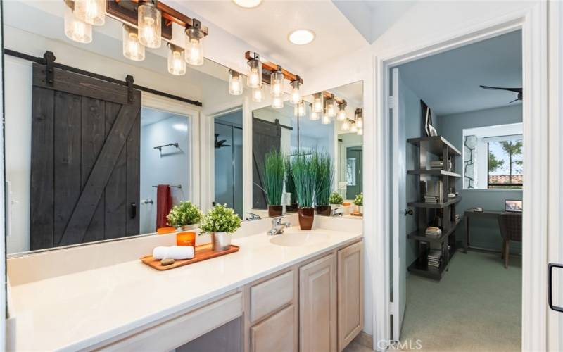 Virtually staged loft/office beyond the primary bath vanity area