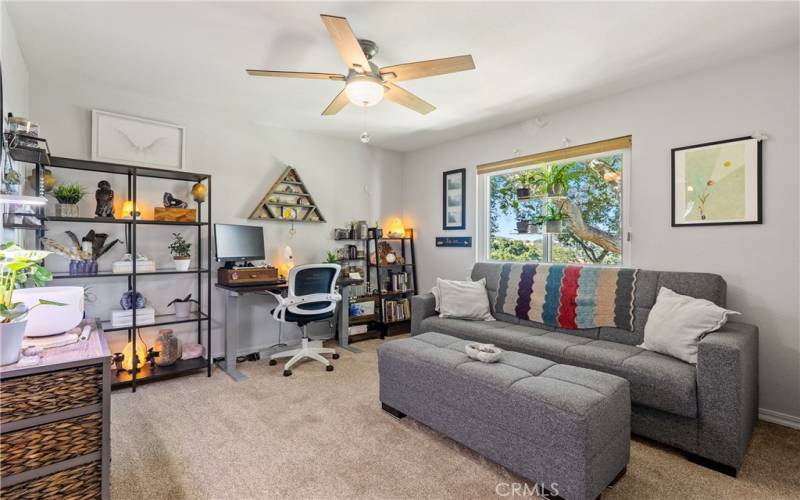 Bedroom 2 features plush carpet, ceiling fan and views out the front of the home.