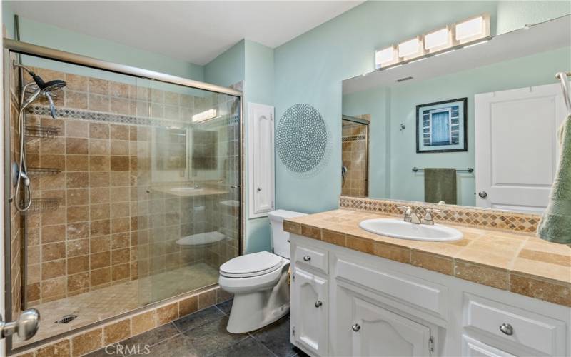 The main bathroom offers a polished look with tiled shower and vanity.