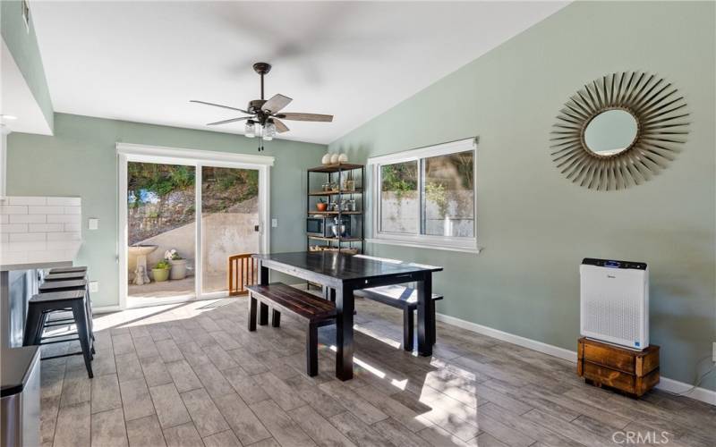 The dining area is brightened by a large window and sliding glass door.