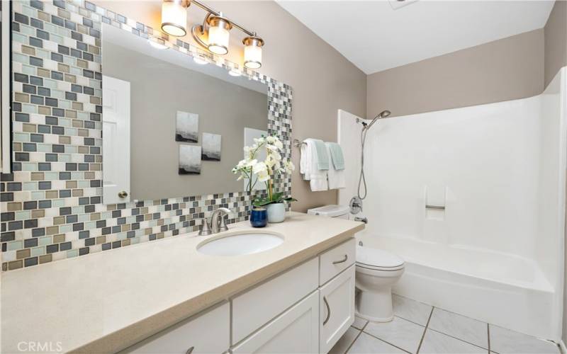 The updated bathroom has quartz counters and a tile backsplash. The tub has

the shower over it and the toilet has an attachment that makes it a bidet.