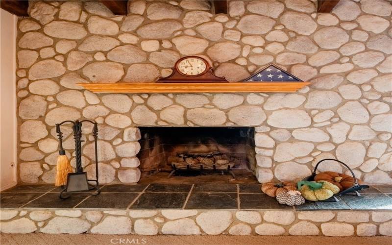 This is a picture of the river rock natural fireplace and hearth in the family room. The fireplace is the focal point of the room, and the river rock hearth adds a rustic touch.