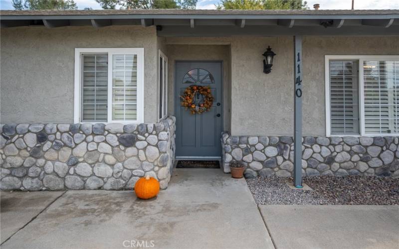 FRESHLY PAINTED EXTERIOR WITH NEW WINDOWS AND SLIDER DOORS ACCENTED BY NATURAL RIVER ROCK.