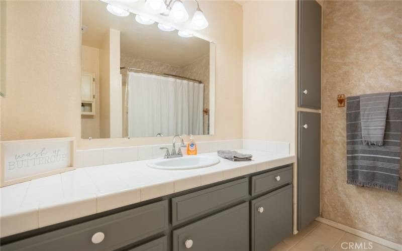 HA LL FULL BATH WITH SHOWER OVER TUB HAS BUILTIN STORAGE OR LINEN CLOSETS.