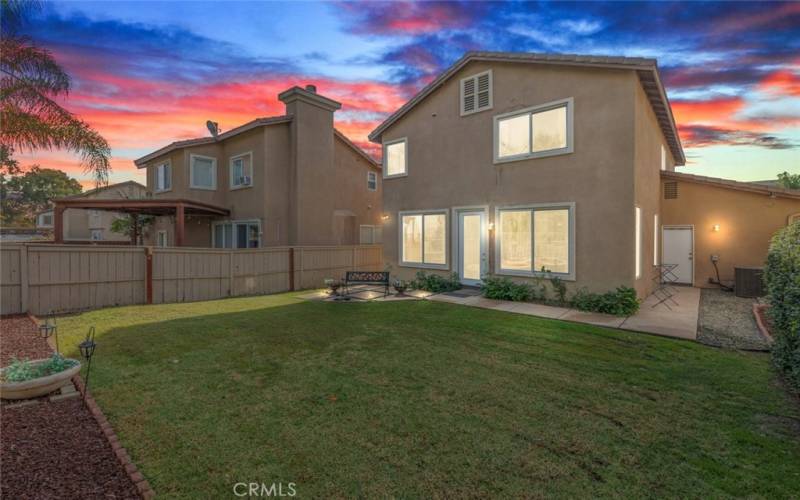 The spacious backyard offers ample room for entertaining, complete with a cozy seating area and plenty of greenery for relaxation.