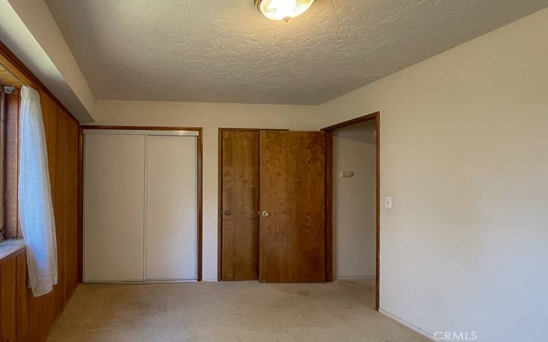 Bedroom number two with knotty pine accent wall