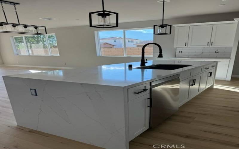 Open kitchen with large quartz waterfall island.