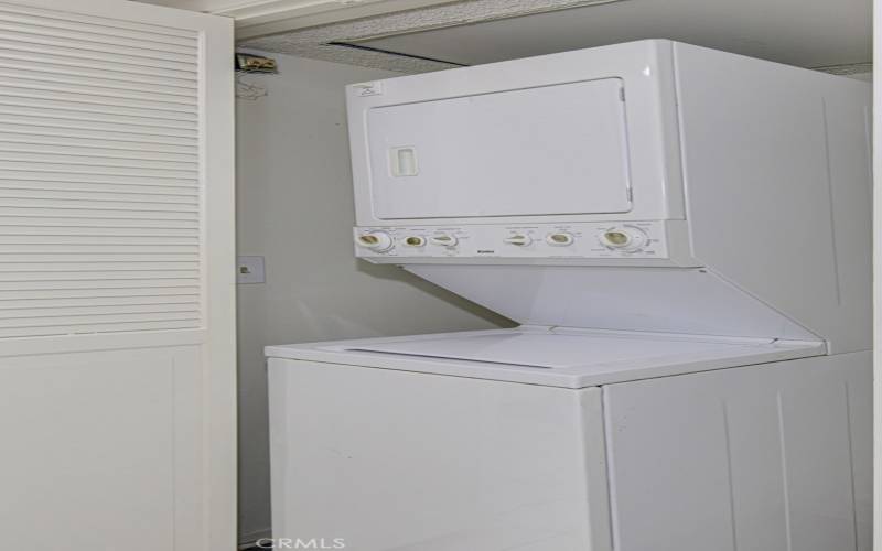 Stacked washer/dryer conveniently located in a hall closet.