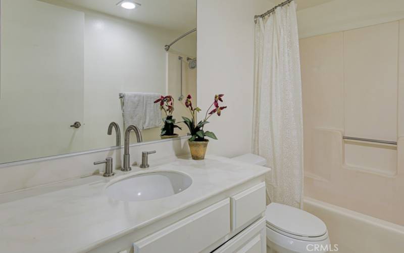 The primary bathroom has a tub with a shower over the tub.