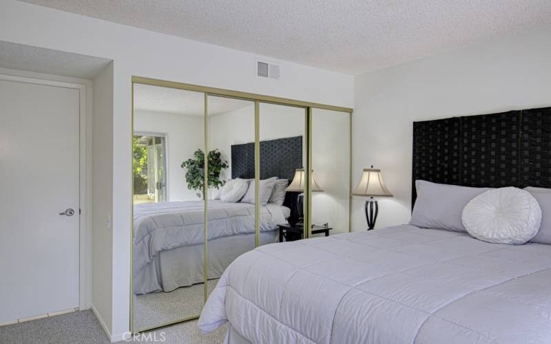 Guest bedroom has a largedmirrored closet.