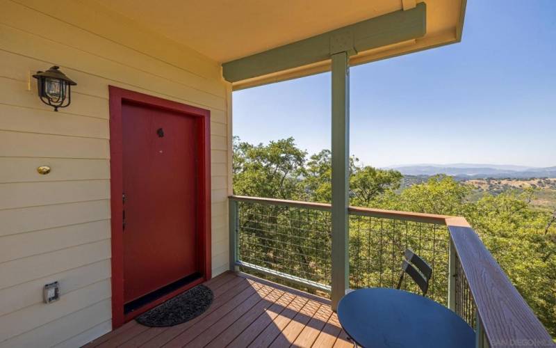 A porchlight and rustic red door greet you and your guests.