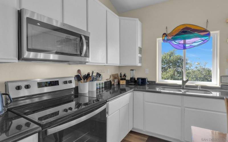 White hand finished cabinets, make a statement with granite counters and stainless-steel appliances