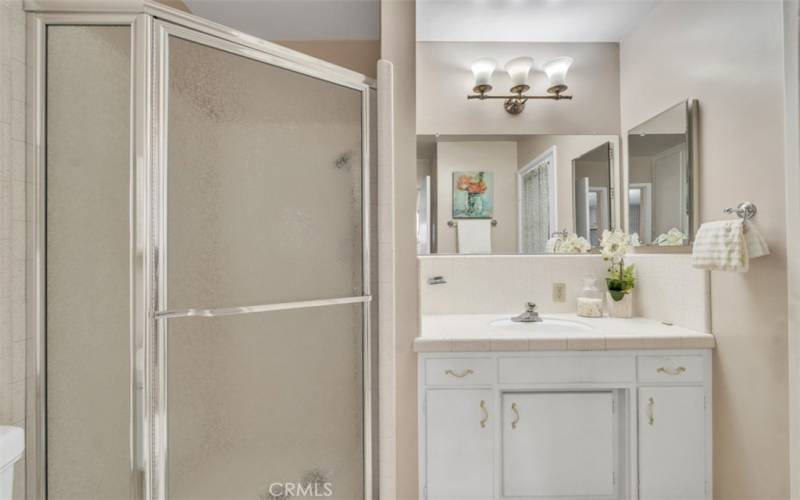 Second bathroom located in the primary bedroom offers a walk-in shower and a separate door that leads to the backyard.