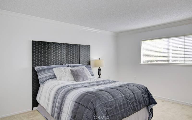 The primary bedroom is very spacious and will accommodate even very large pieces of furniture.  This bed is a queen size.  The room will easy accommodate a king size bed and two nightstands.