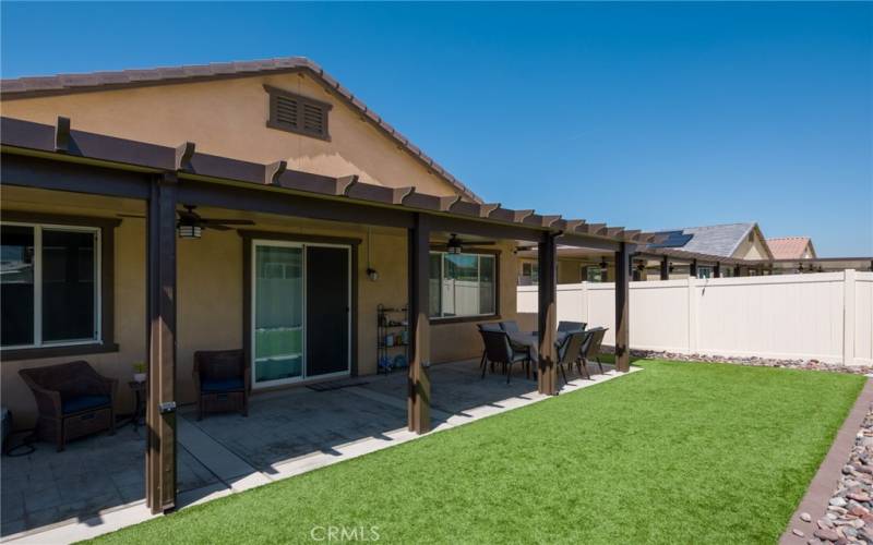 Back yard with artificial turf, alumawood patio cover and stamped concrete patio.