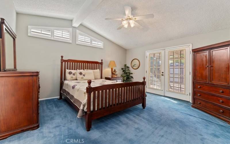 Primary Bedroom with Plantation Shutters and French Doors to Backyard! There is also a walk-in closet