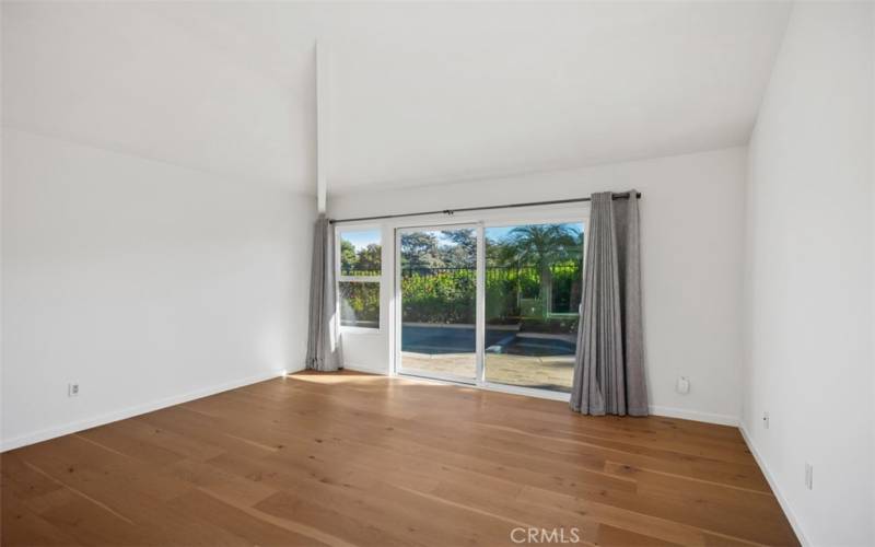 Primary bedroom with vaulted ceilings and views out to the back pool/spa.