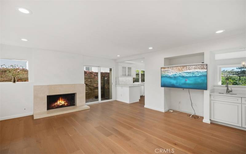 Den located off the living room and kitchen. TV included. Notice the wet bar to the right of the TV and fireplace.