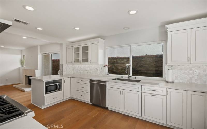 Kitchen with quartz counters and recessed lighting.