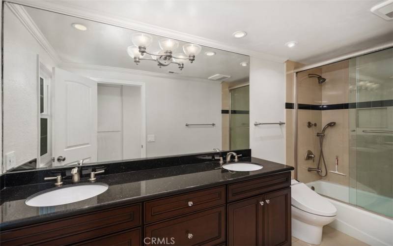 Guest bathroom 1 with dual vanity sinks and bath/shower combo.