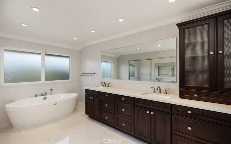 Primary bathroom with free standing tub and dual vanity sinks. Additionally there is a  closet located here.