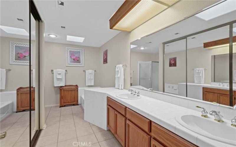 Primary bath with dual sinks, walk-in closet, tub and separate shower.