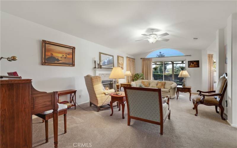 Living room has a vaulted ceiling and a sliding door to the patio.