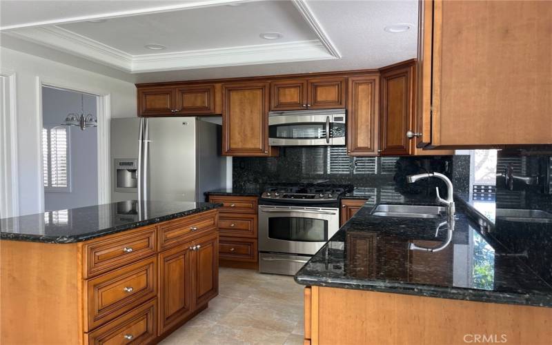 Kitchen is well appointed, custom cabinets, plenty of storage, walk in pantry, recessed lighting