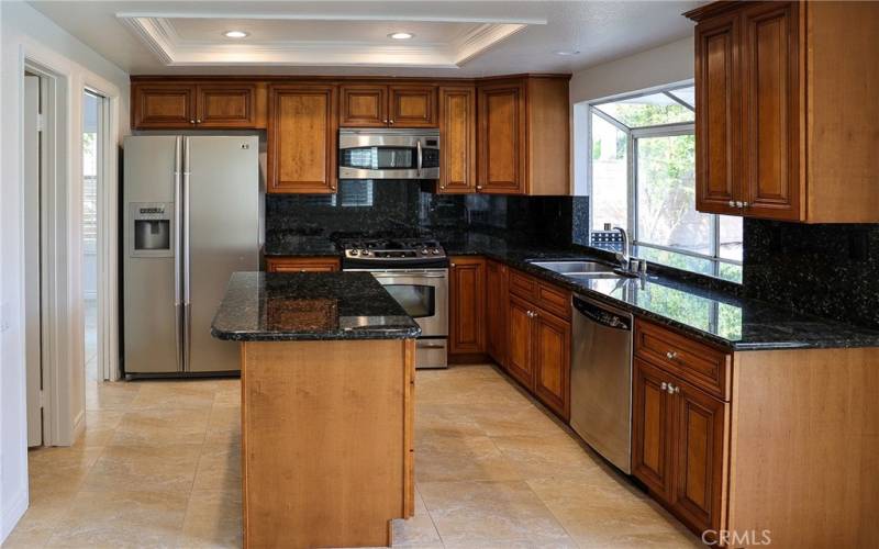 Kitchen is spacious with island, plenty of counter space, garden window looks out to hills view and night lights.