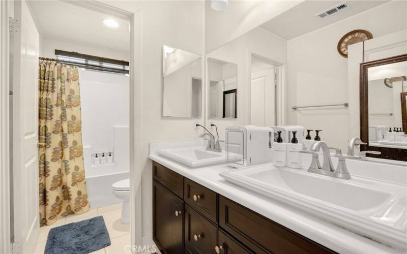 upstairs  guest bathroom with dual sinks