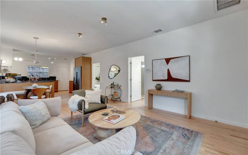 Open concept living area with brass fixtures and pristine hardwood floors