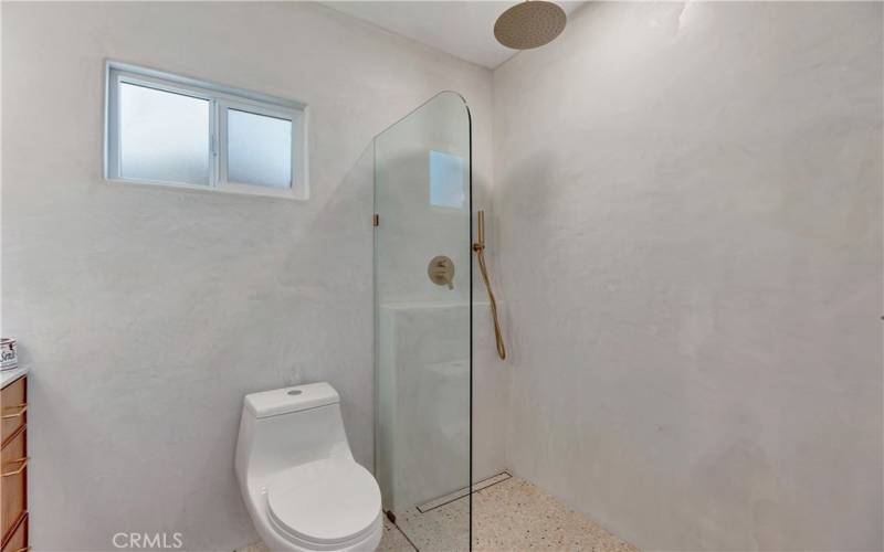 Primary bathroom with sleek frameless glass wet room and smooth Santa Barbara waterproof stucco