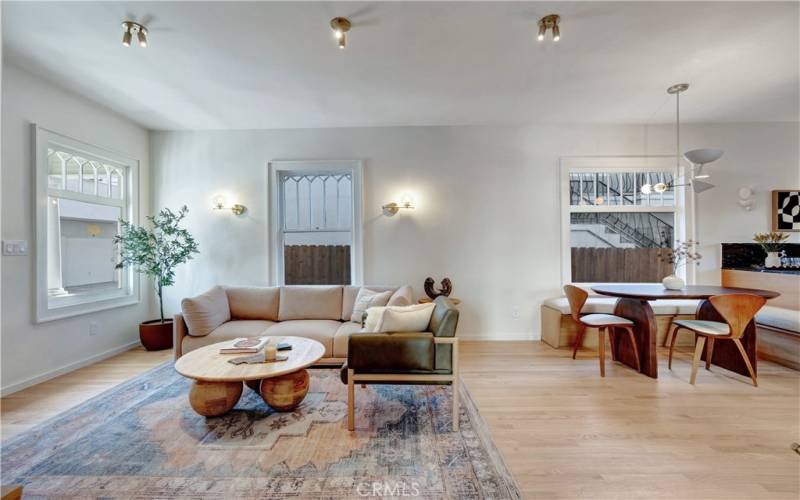 Open concept living area with new hardwood floors and mid-century modern light fixtures