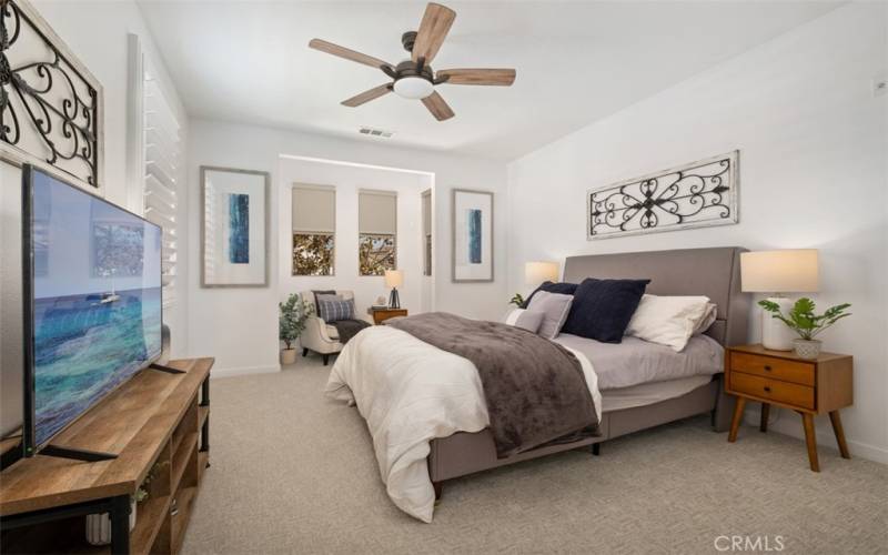 Master bedroom with sitting area by the windows.