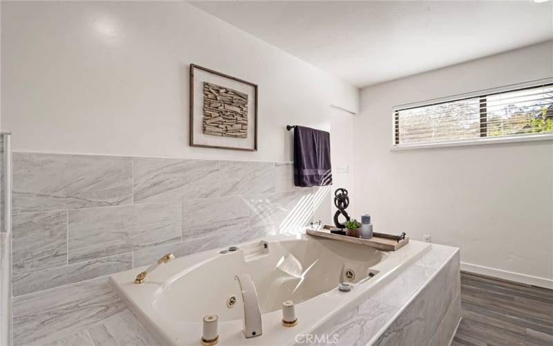 Primary bathroom with jetted tub with marble surround