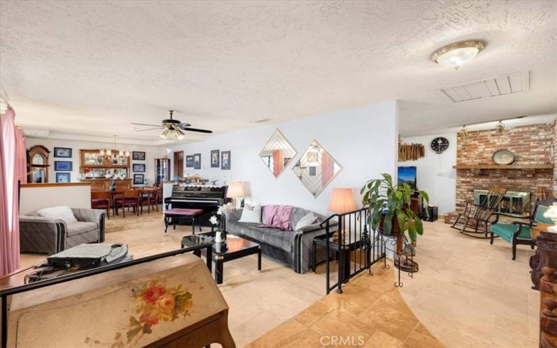 Primary Home - Looking From the Front Entry into the Step Down Living Room, Formal Dining Room and Family Room with Brick Fireplace