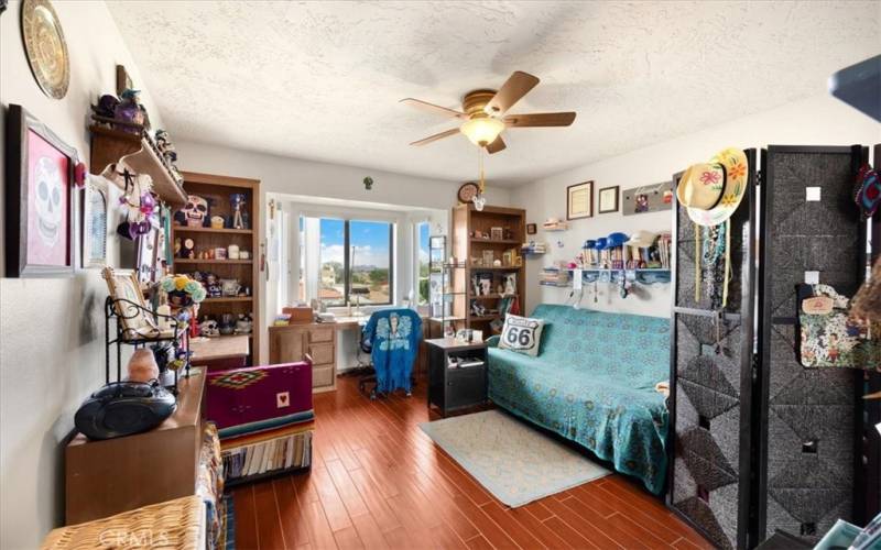 Primary Home - Bedroom #2 - Featuring Built in Bookshelves and Desk, Bay Window and Wood Look Tile Flooring