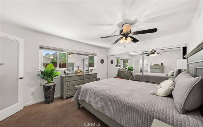 Primary suite, ceiling fan and large closet with mirrored doors.