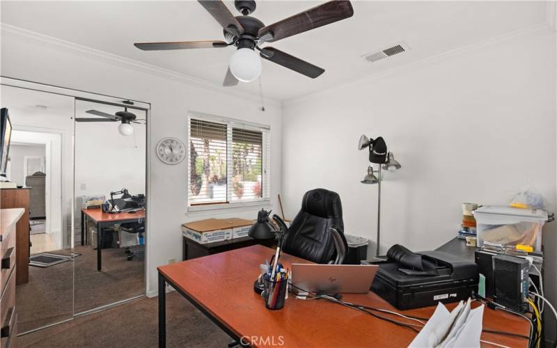 Guest bed currently being used as an office.  Natural light, mirrored closet doors and a ceiling fan make this room comfortable.