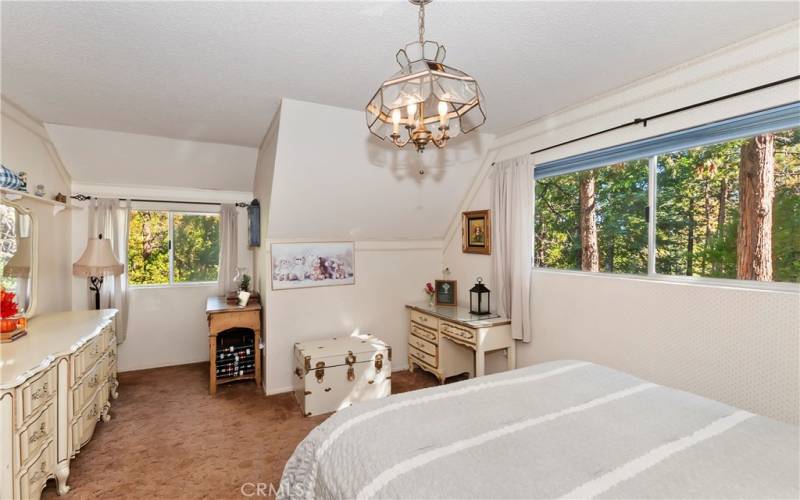 2nd bedroom at top of stairs with view of trees