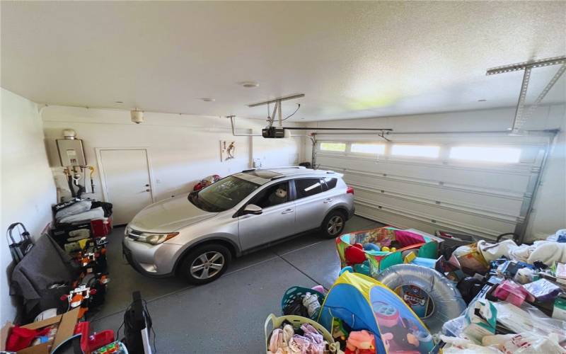 Bright and spacious 2-car garage featuring sleek epoxy flooring and convenient backyard access