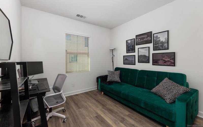 Spacious guest bedroom on the second floor features luxury vinyl flooring and is currently being used as a home office.