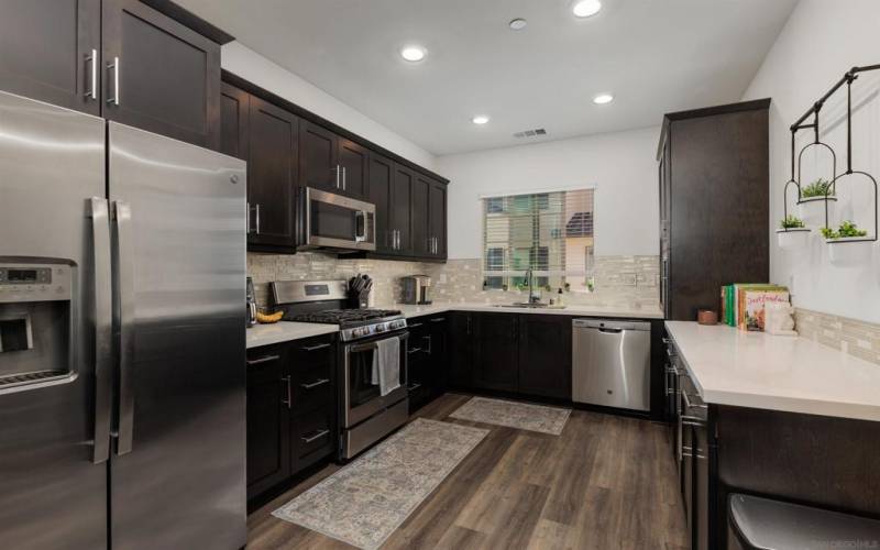 Gourmet kitchen is equipped with high-end finishes, beautiful quartz countertops, and stainless steel appliances.